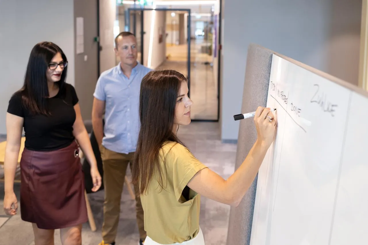 Project management team in the office next to the writing board
