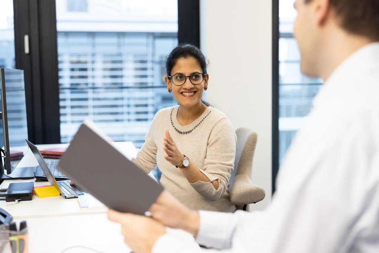 Colleague smiling at the desk at Zühlke office