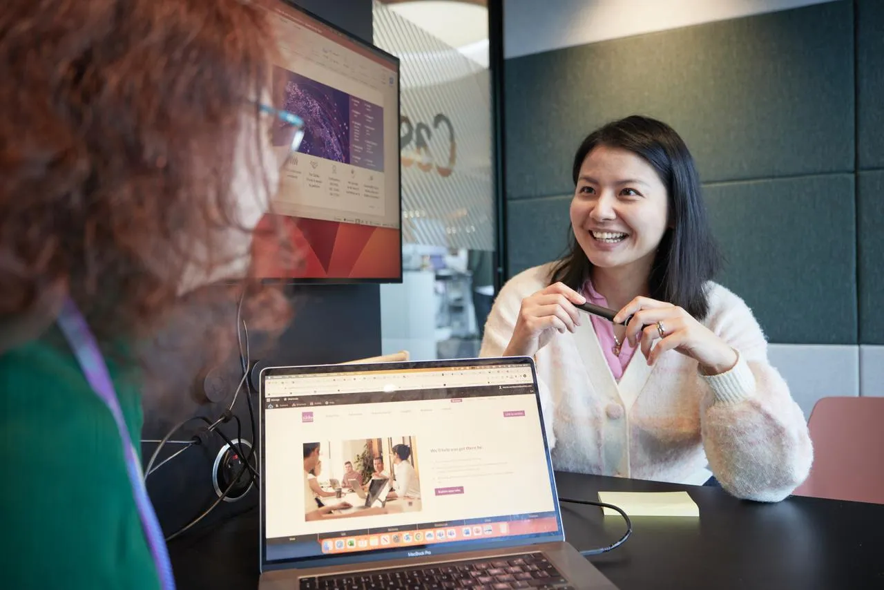 Women in the small office meeting room booth smiling