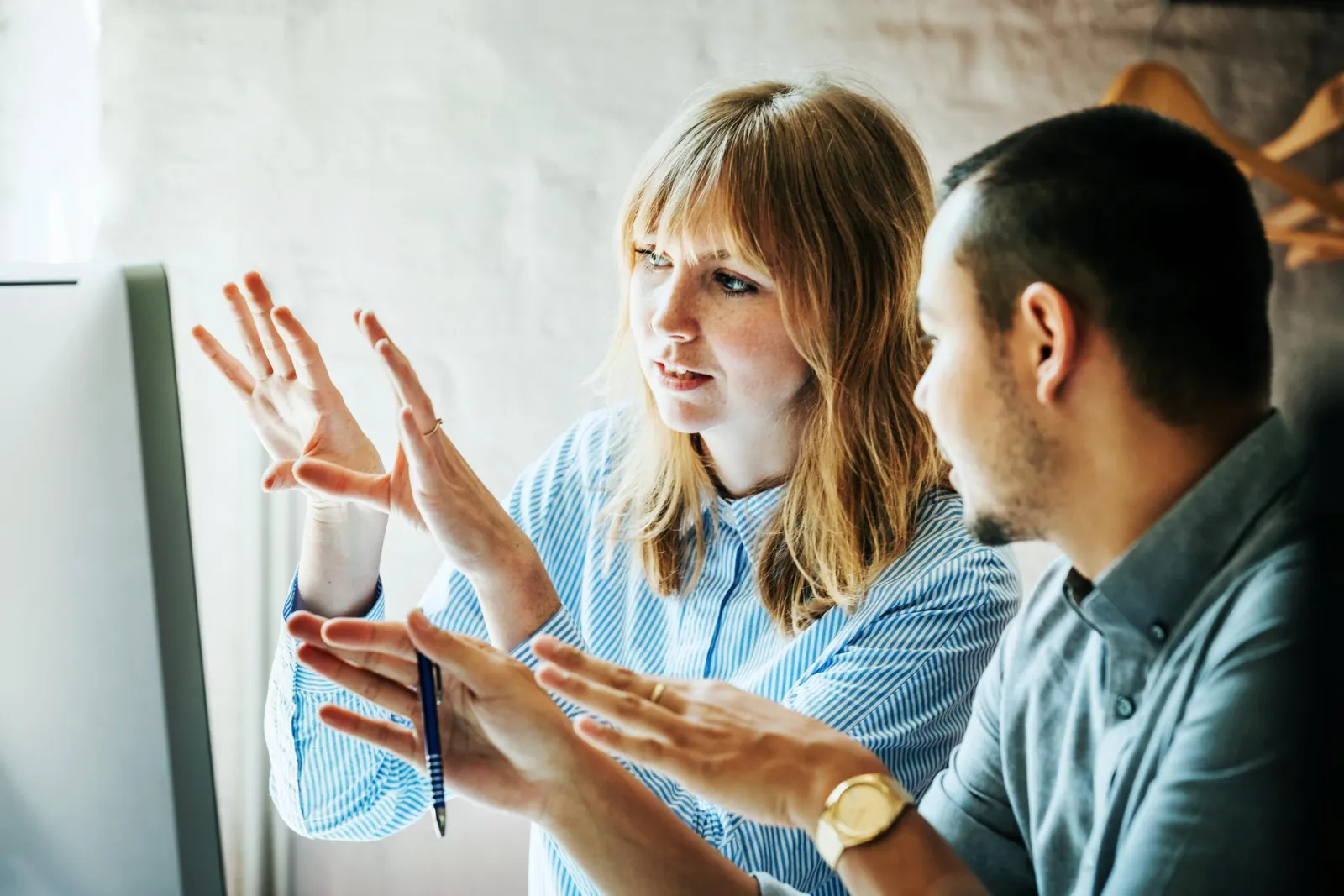 Two colleagues problem-solving at computer together