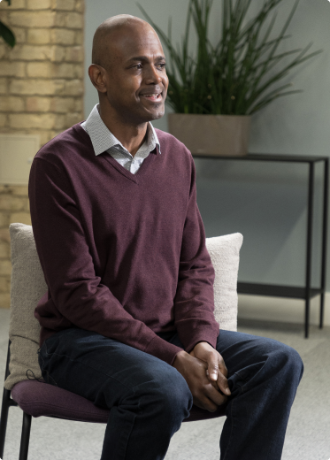 Man sitting, wearing a red Shirt