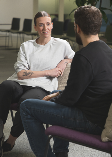 Woman sitting on a chair, looking at a man