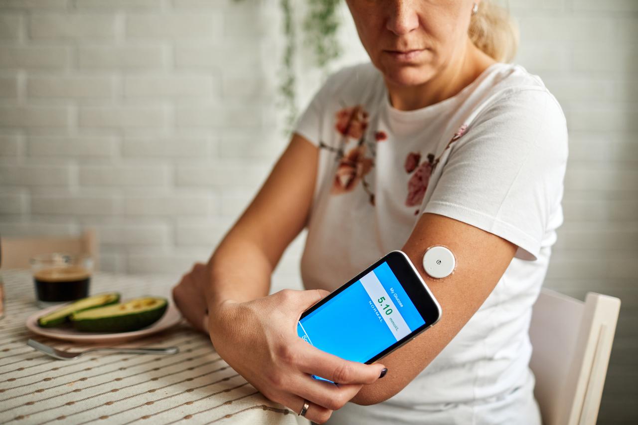 Mature Woman Swiping Sensor With Smart Phone For Glucose Mesaurement