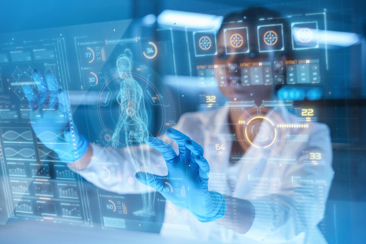 A young African-American scientist in a modern laboratory studies human body with HUD or graphic display