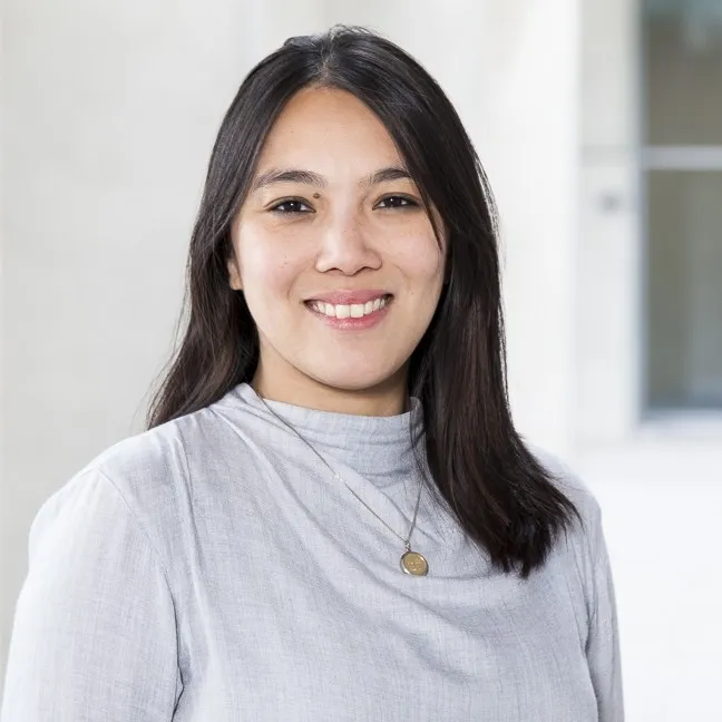 A young woman's smiling portrait in a neurtal white setting