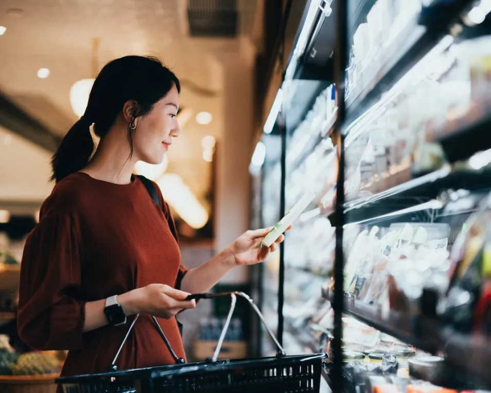 Woman using loyalty app in grocery store