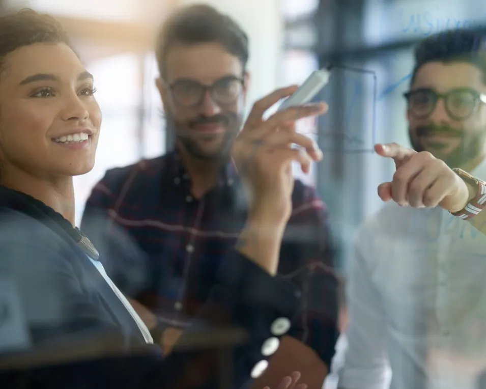 Team collaborating at a glass board, mapping out strategies for AI risk management.