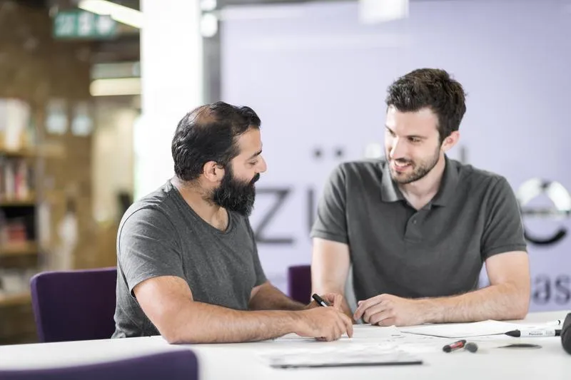 two male individuals at a meeting at the table