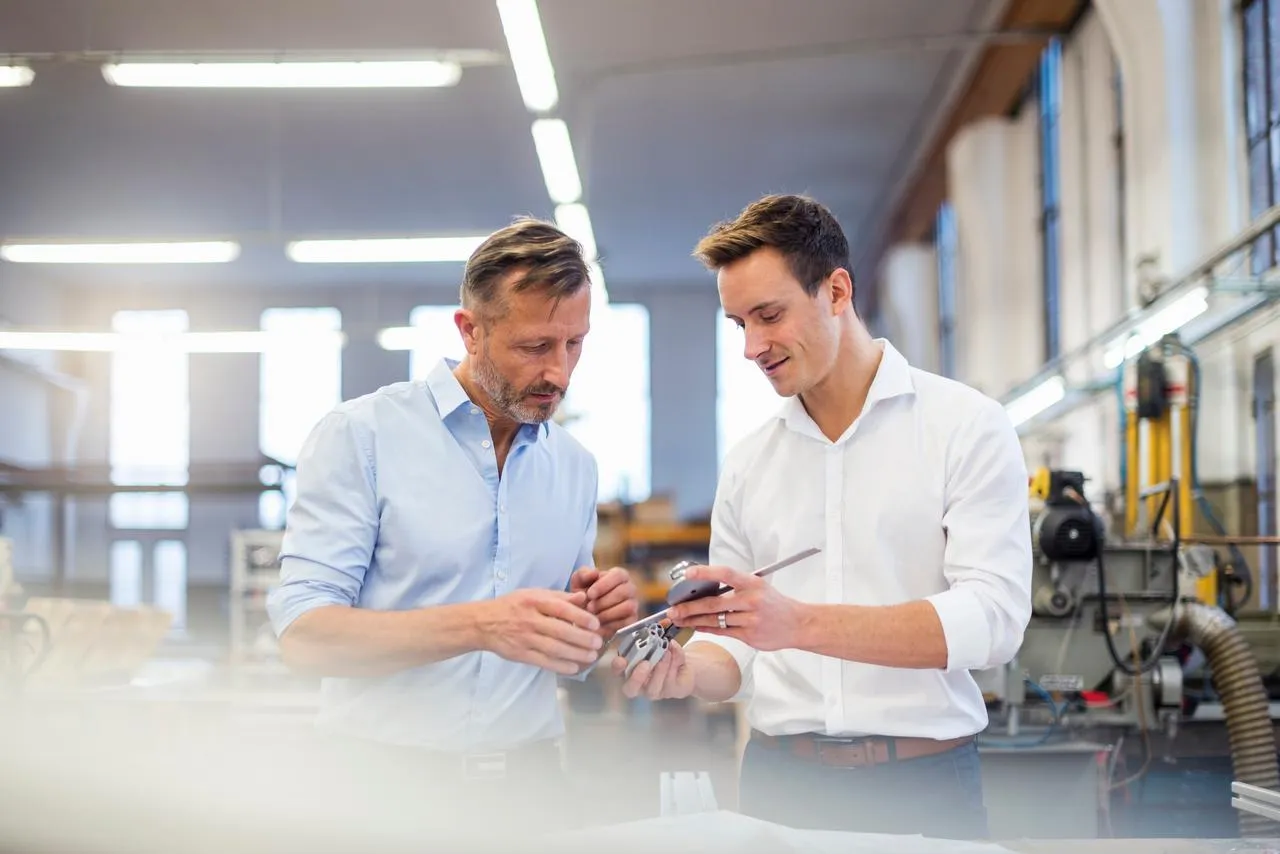 Two business men in a factory inspecting a product